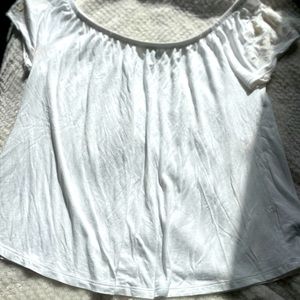 White blouse with flowers on the sleeve.